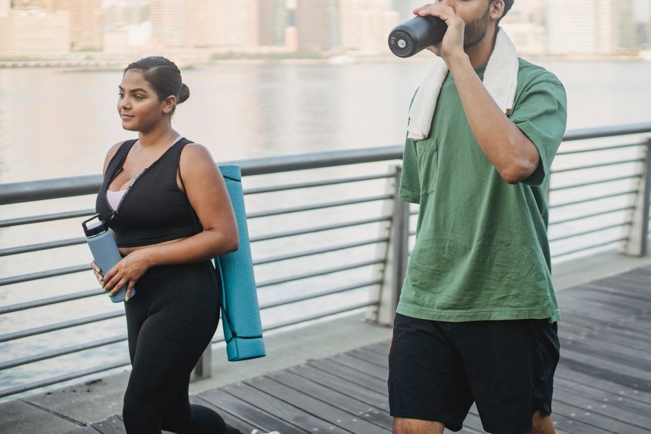 A couple engages in fitness walking by the riverside, embodying a healthy lifestyle.
