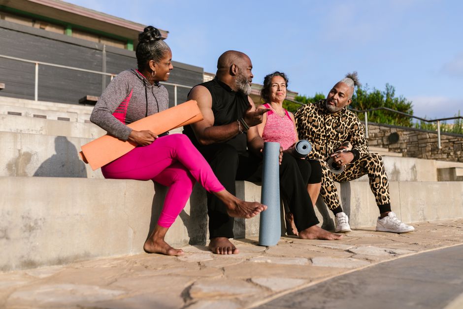 A diverse group of seniors relaxing with yoga mats outdoors, embracing wellness and togetherness.