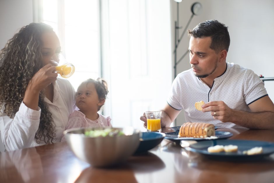 A family having breakfast at home, sharing food and drinks, embodying togetherness and love.