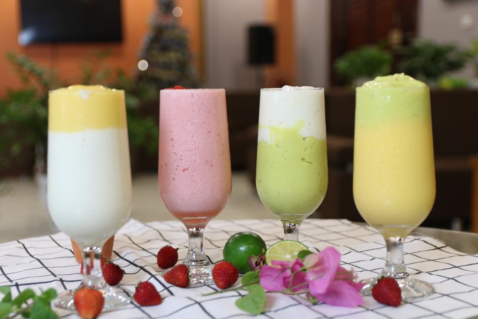 A vibrant array of healthy fruit smoothies in wine glasses, perfect for a balanced diet.