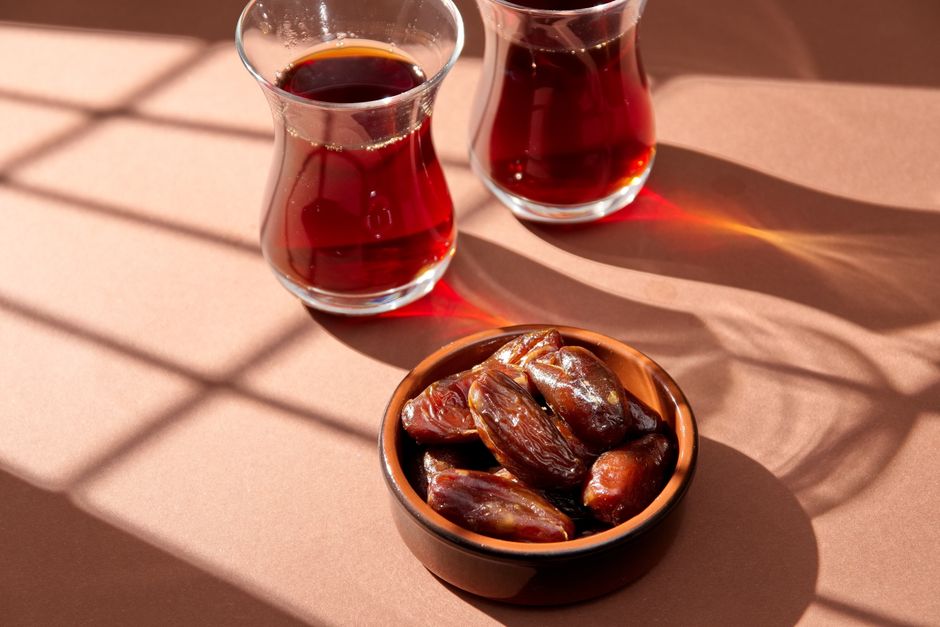 A warm composition of Turkish tea and dates bathed in sunlight with beautiful shadows.