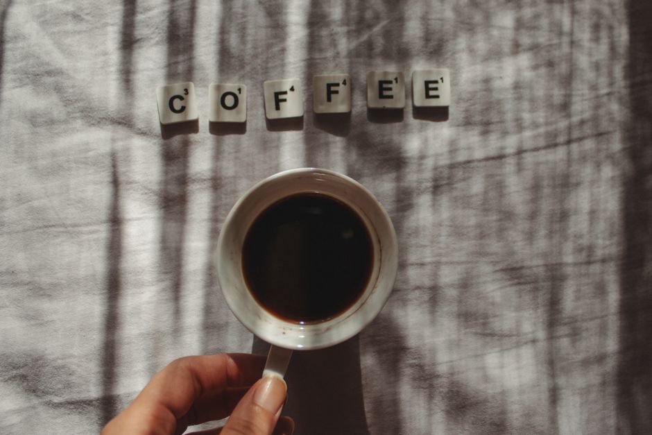 Artistic coffee cup scene with scrabble letters spelling coffee. Perfect for beverage lovers.