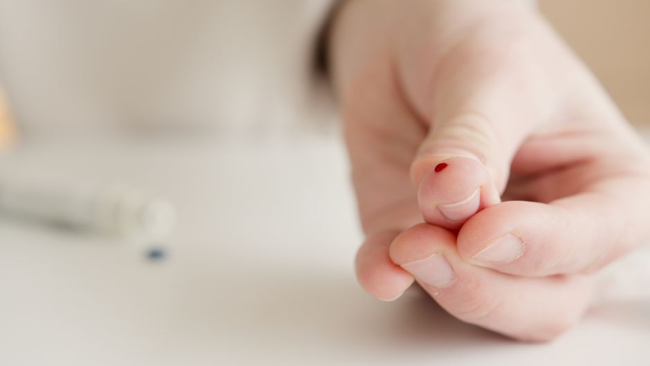 Close-up of a hand with a finger prick for home blood testing. Ideal for health and medical themes.