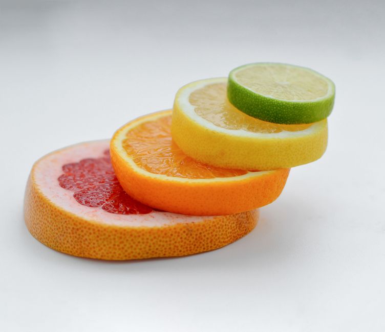 Colorful stack of citrus slices - grapefruit, orange, lemon, lime - showcasing freshness and health benefits.