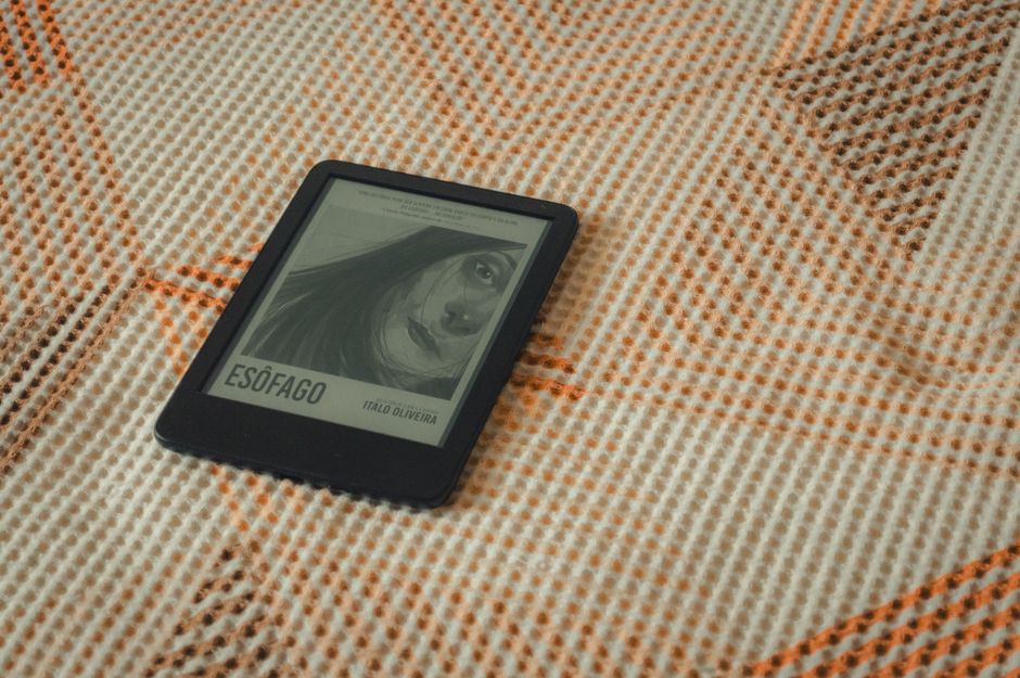 E-reader displaying a book cover resting on a cozy textured blanket.