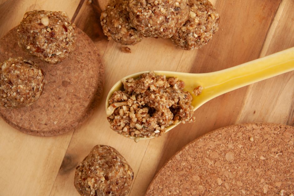 High-angle view of nutritious energy balls and granola on a spoon, perfect for a healthy snack.