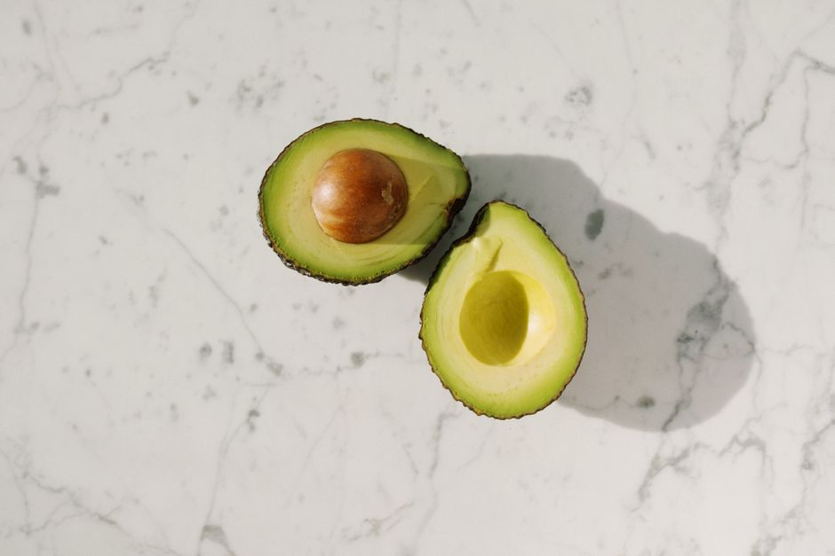 High-quality image of fresh avocado halves on a marble surface, perfect for food blogs.
