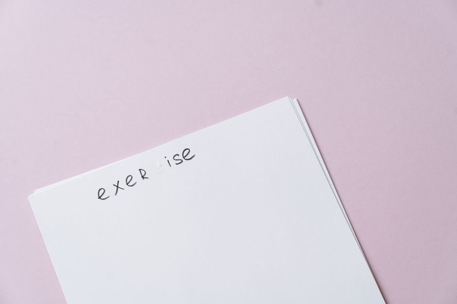 Minimalist image of a blank exercise page on a pink background.
