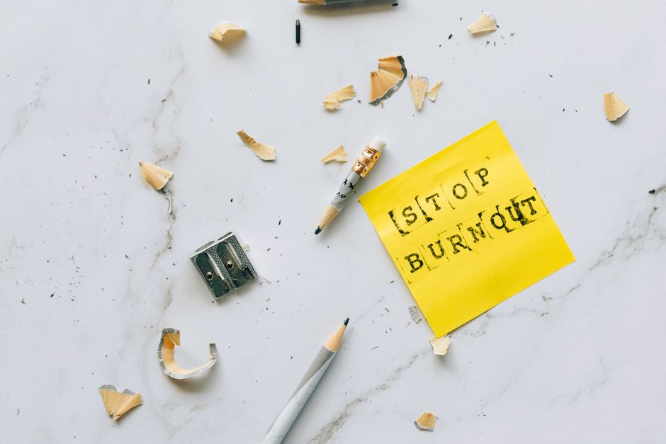 Pencil and shavings with 'Stop Burnout' note on marble surface convey stress relief concept.