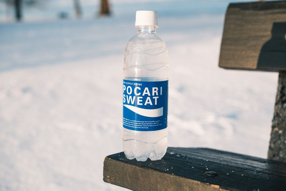 Pocari Sweat bottle on a snowy bench, capturing a winter outdoor setting.