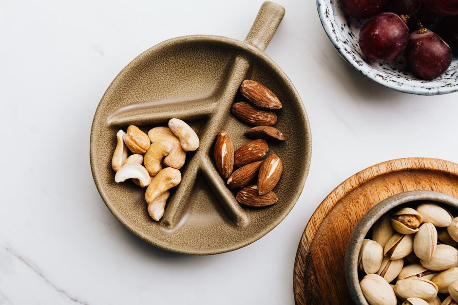 Variety of nuts displayed in a ceramic dish. Perfect choice for a healthy snack.