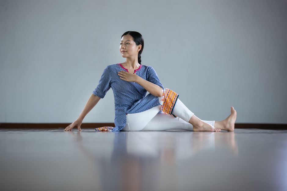 Woman performing a yoga stretch indoors, showcasing flexibility and tranquility.
