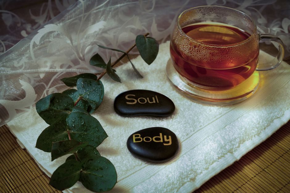 A calming ambiance with eucalyptus, tea, and engraved stones promoting relaxation and wellness.