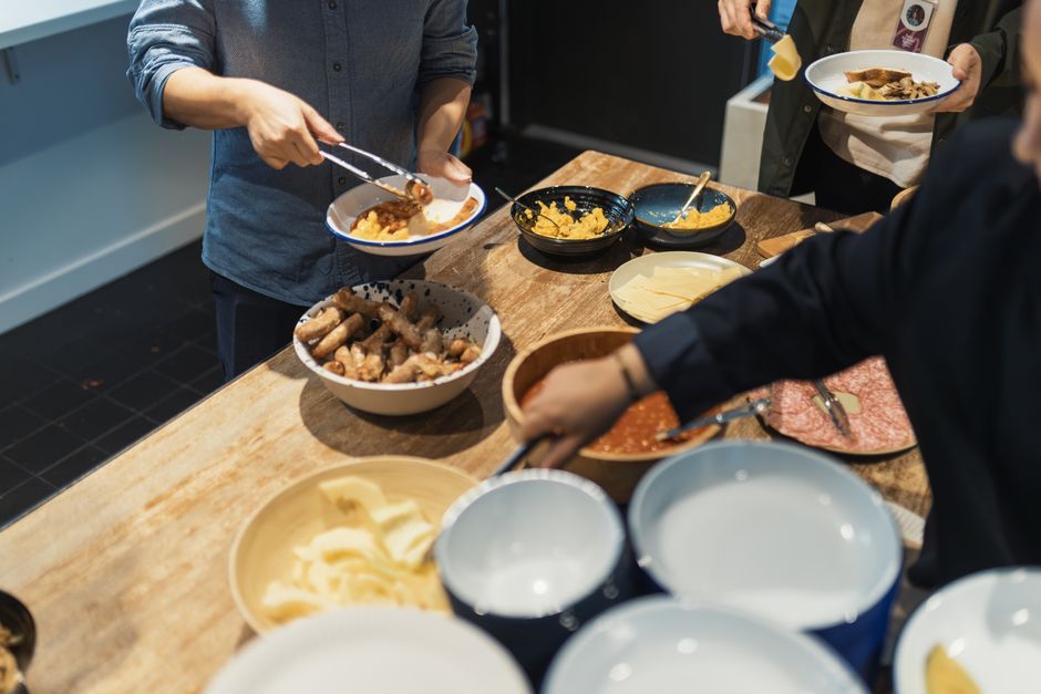 A casual meal setting with diverse dishes being served and enjoyed in a buffet style.