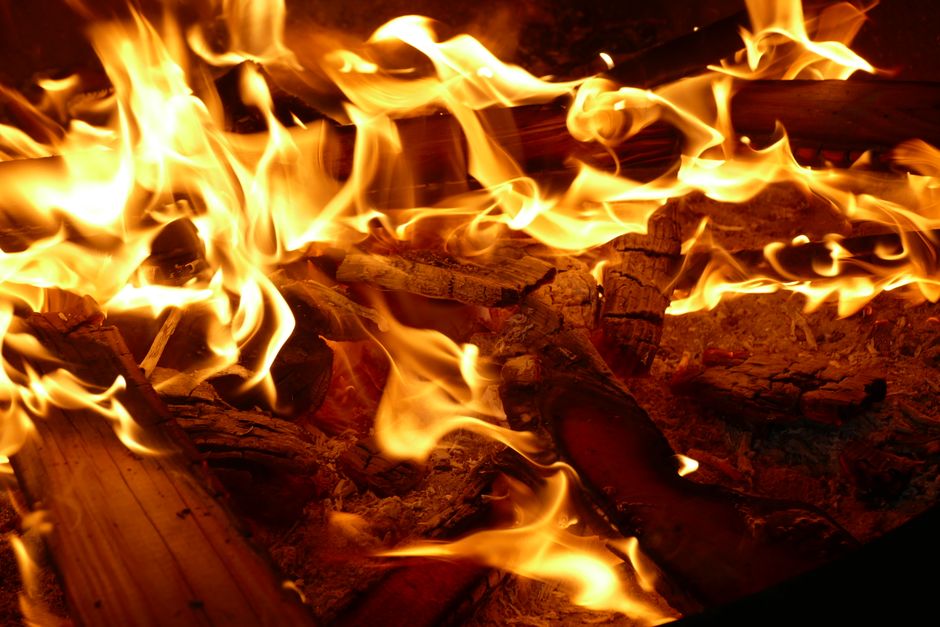 A close-up view of vibrant flames consuming firewood, showcasing the dynamic movement of fire.