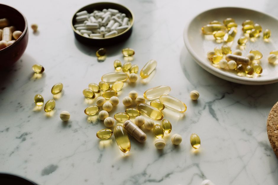A collection of capsules and tablets on a marble surface, highlighting healthcare and wellness.