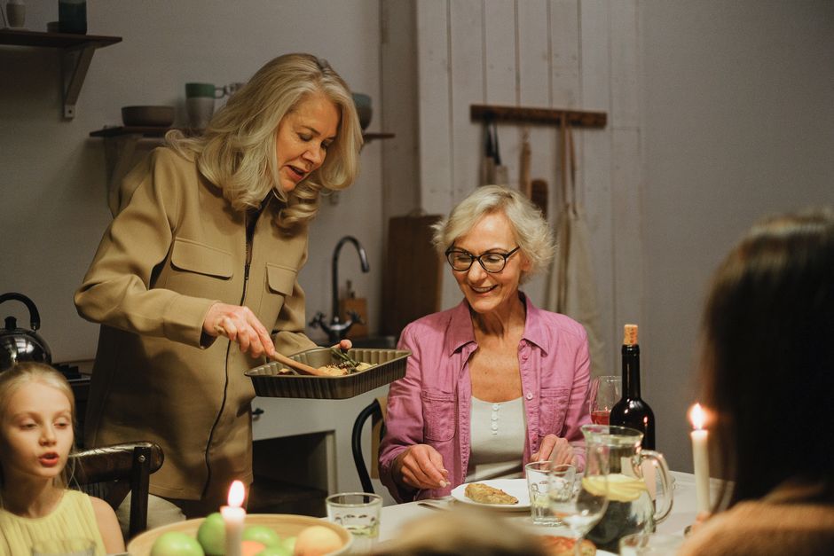 A family enjoys dinner together with warmth and conversation in a cozy indoor kitchen.