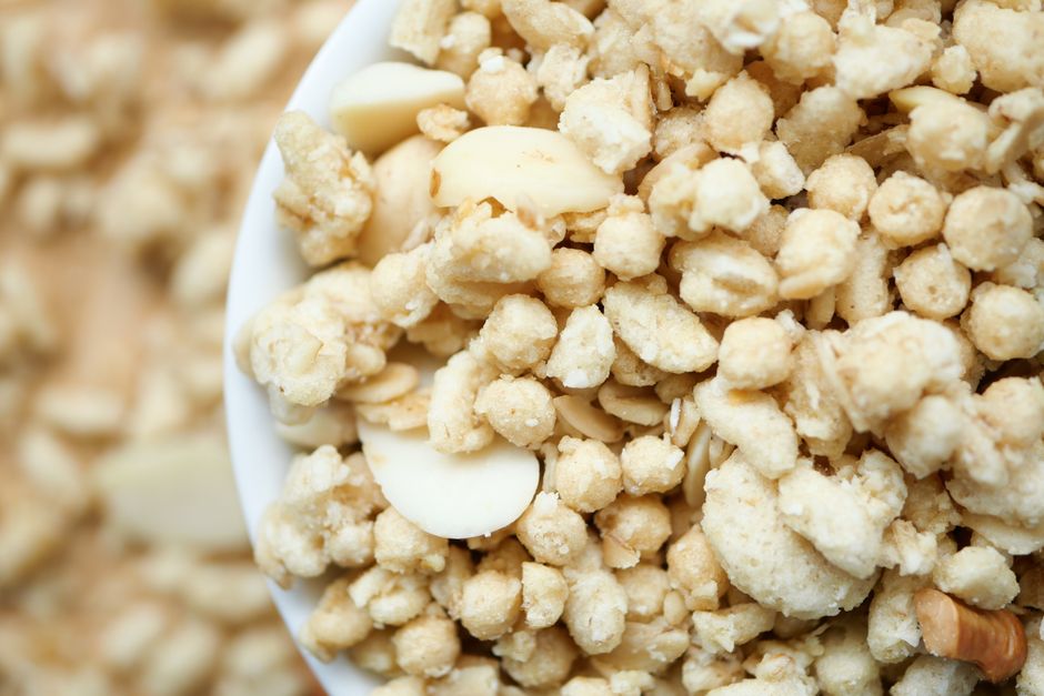 A high-resolution close-up of a bowl filled with crunchy cereal and nuts, emphasizing texture.