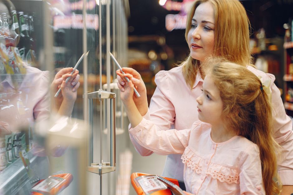 A mother and daughter exploring product options in a supermarket aisle.