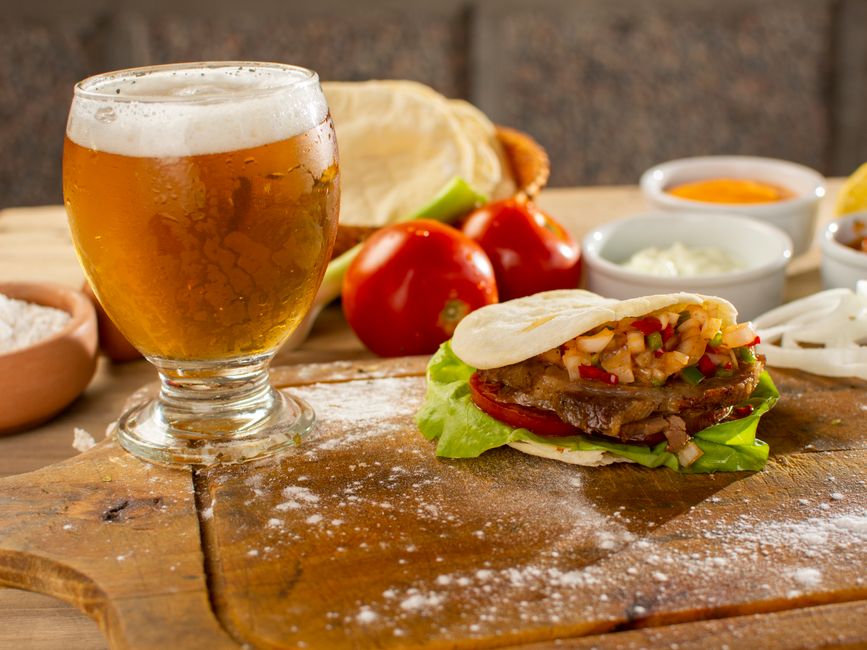 A mouthwatering Argentine sandwich paired with a refreshing beer, perfect for a delightful meal.