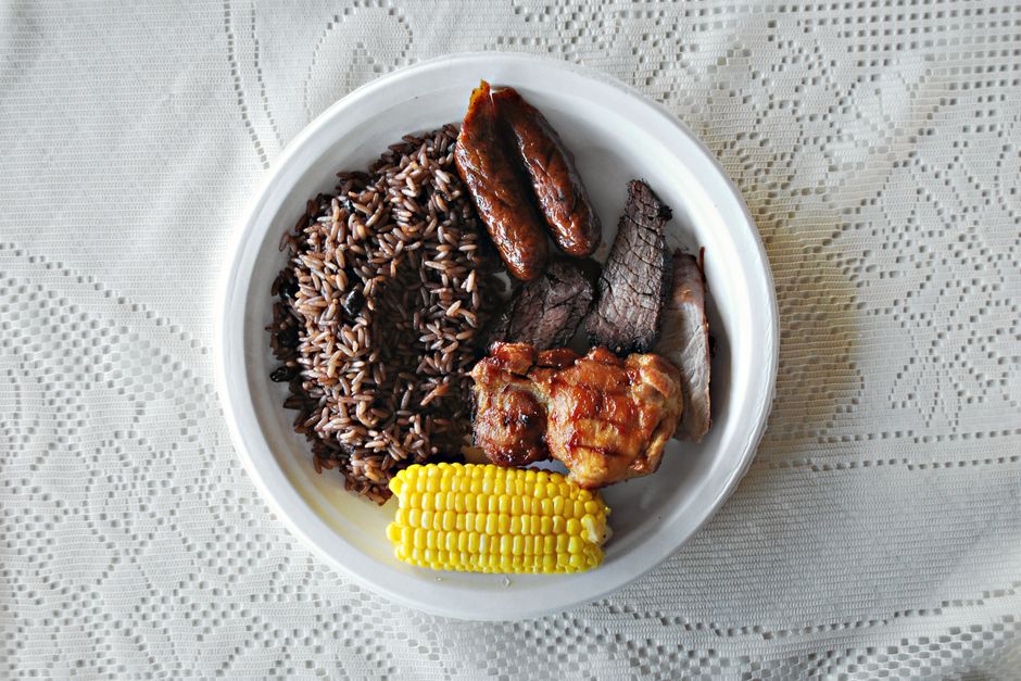 A mouthwatering platter of grilled meat, rice, and corn on a lace tablecloth.