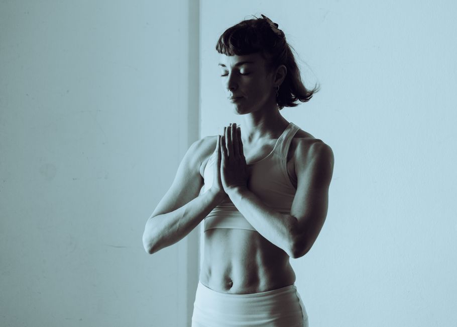 A serene woman meditating and practicing yoga indoors, conveys calm and mindfulness.