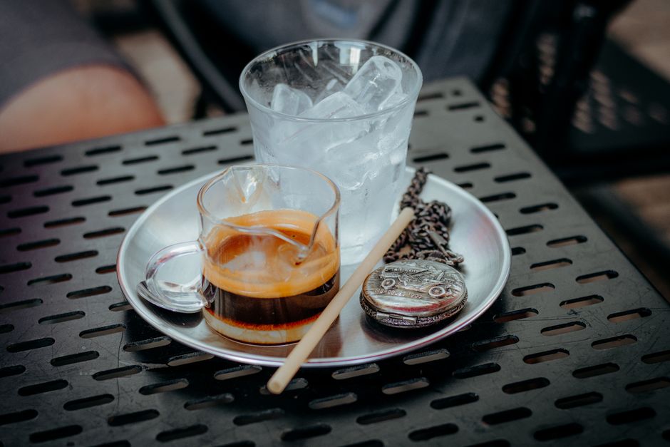 A stylish setup of espresso and ice on a metal tray, perfect for cafes.