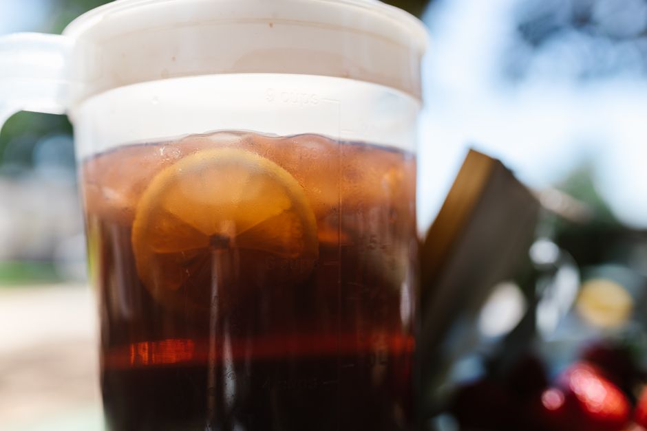 Close-up of a refreshing iced tea with lemon slice outdoors in summer.