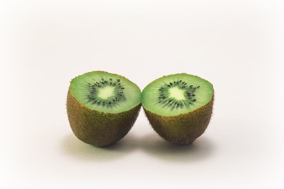 Close-up of two fresh kiwi halves displaying vibrant green color and texture, highlighting freshness and nutrition.