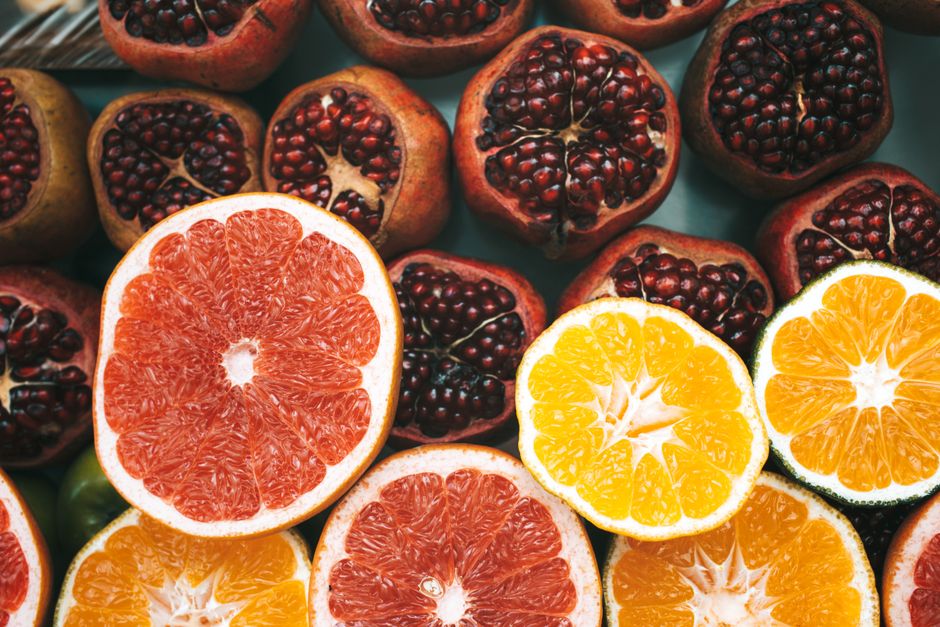 Close-up view of colorful sliced citrus fruits and pomegranates showcasing freshness and nutrition.