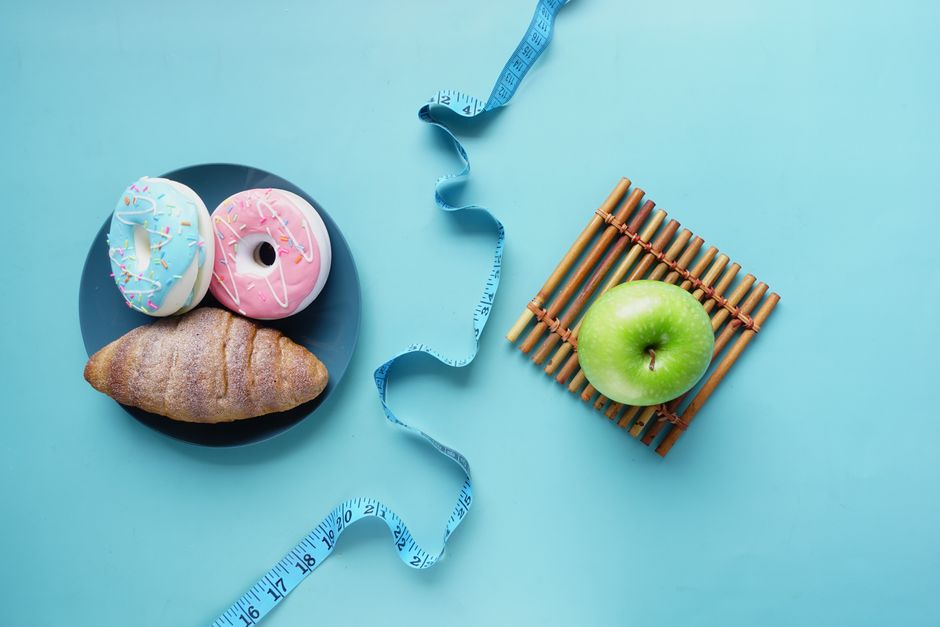 Contrast of healthy and indulgent foods with a measuring tape for weight management.