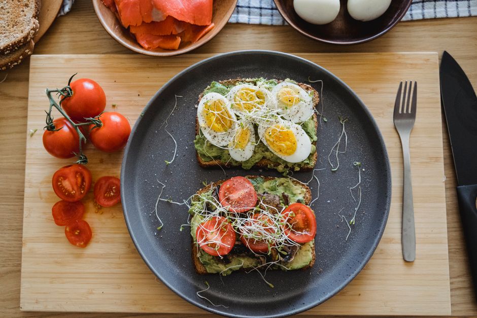 Delicious avocado toast topped with fresh eggs and tomatoes, perfect for a healthy breakfast or lunch.