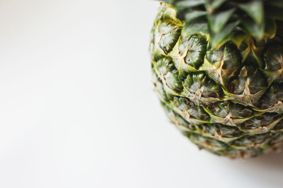 Detailed close-up of a fresh pineapple against a white background. Perfect for tropical themes.
