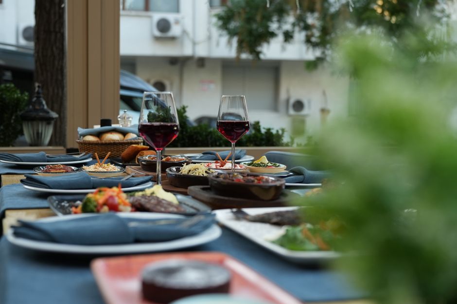 Elegantly set outdoor dining table with wine glasses and assorted dishes, evoking a relaxing dining experience.