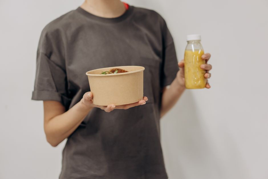 Faceless woman holding a rice bowl and juice bottle, representing healthy lifestyle and nutrition.