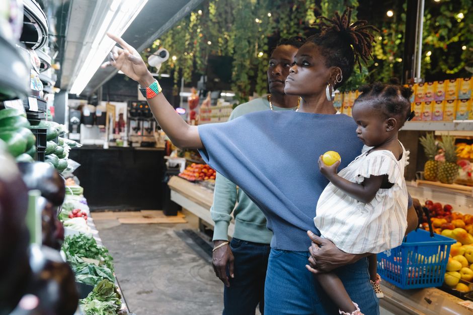 Family shopping for fresh produce in a vibrant supermarket, choosing healthy options together.