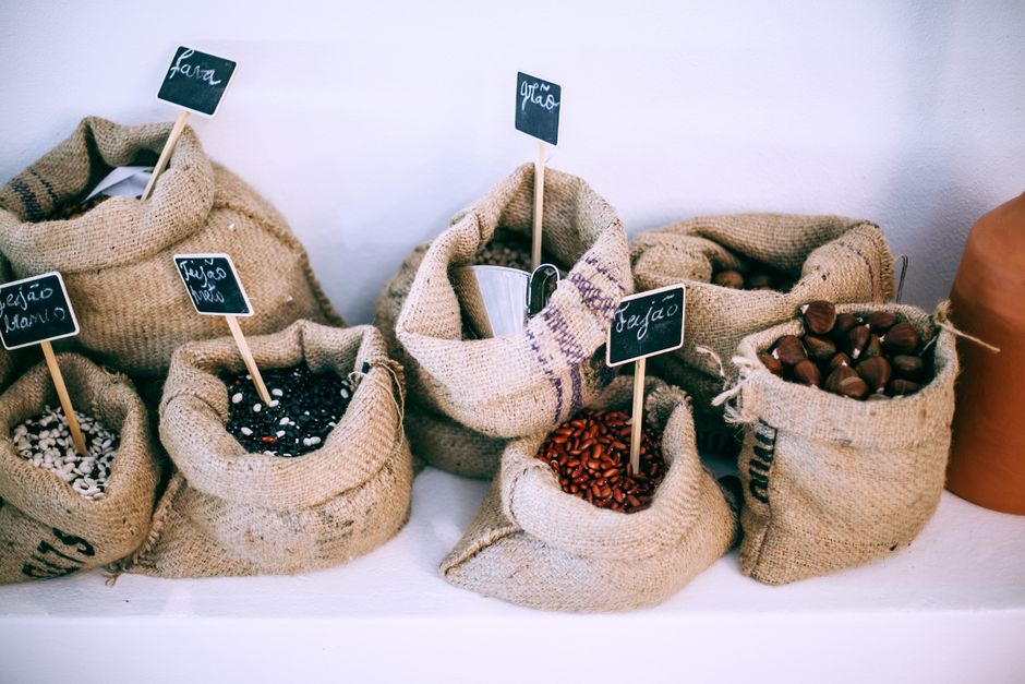 From above of organic bags with assorted beans and chestnuts with signboards on shelf for sale