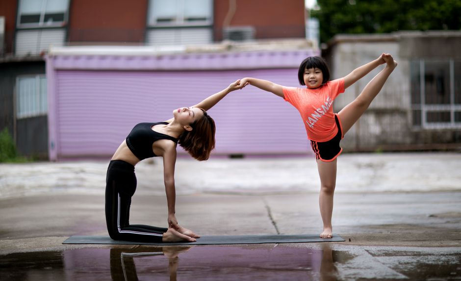 Mother and daughter enjoying yoga together outdoors, promoting health and bonding.