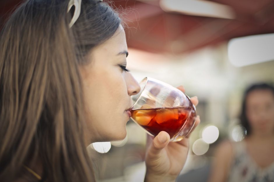 Profile of a woman drinking a refreshing beverage, capturing a moment of quenching thirst.