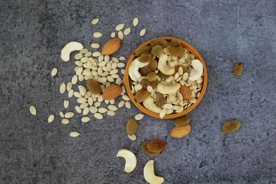 Top view of assorted dry fruits in a bowl on a rustic surface, showcasing a healthy mix.