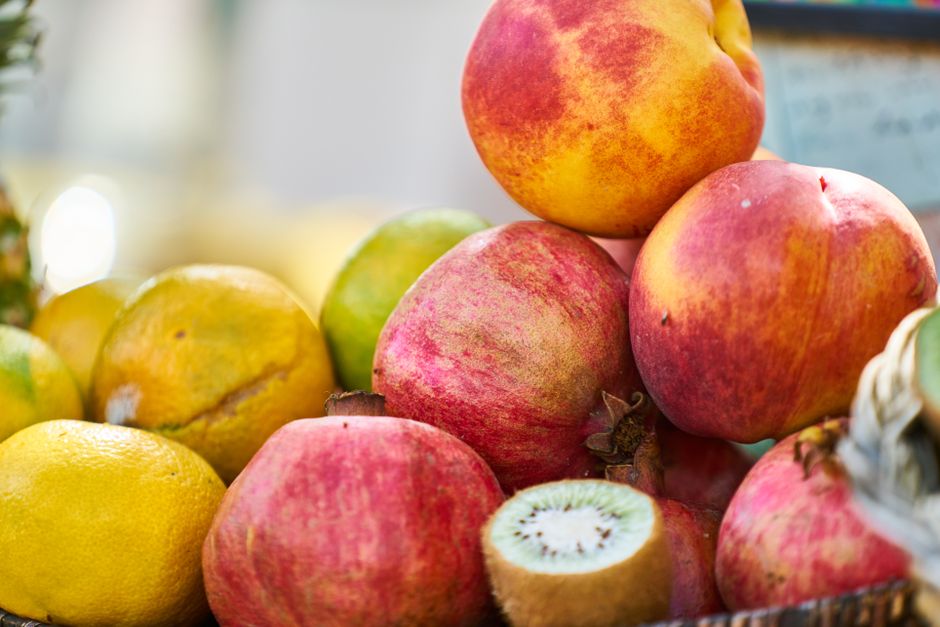 Vibrant assortment of fresh fruits including citrus, kiwi, and pomegranate, showcasing healthy, colorful produce.