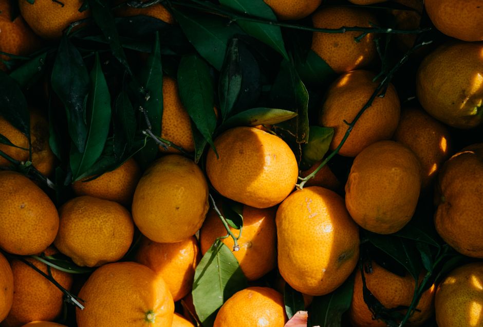 Vibrant organic mandarins with green leaves, showcasing natural freshness and vitamin C richness.