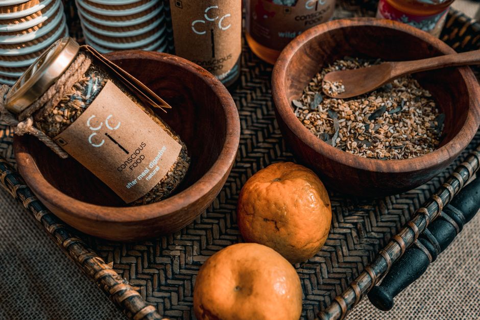 Warm still life featuring organic spices in bowls, fresh tangerines, and conscious food branding.