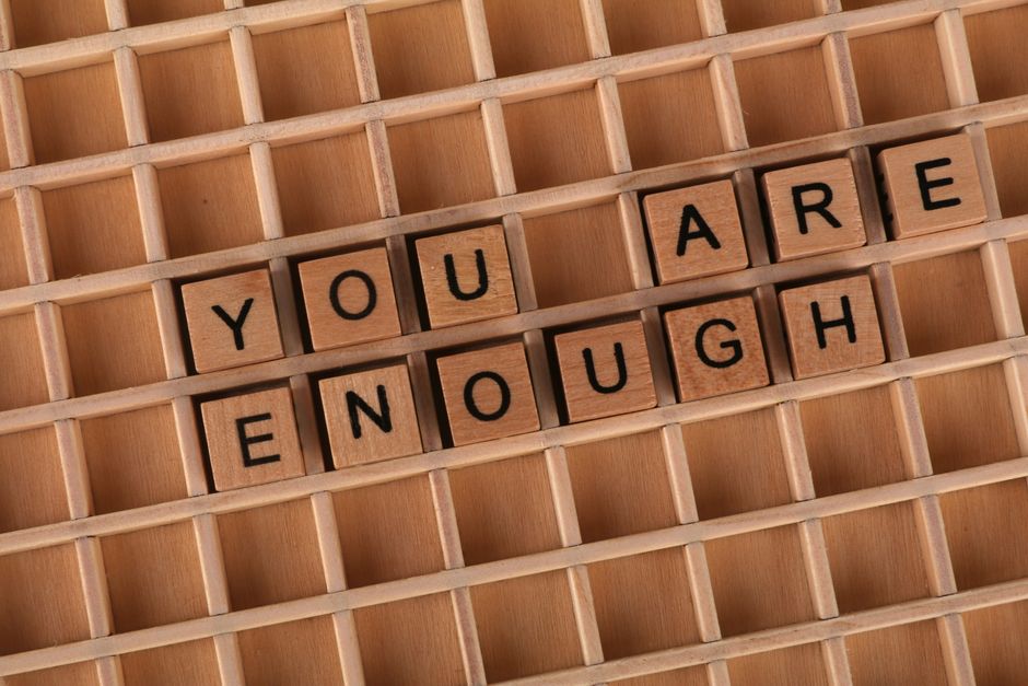 Wooden letter tiles spell out 'You Are Enough'. Positive and motivational concept.