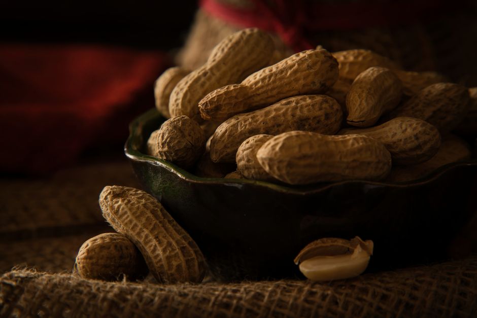 A bowl full of organic peanuts in their shells, perfect for healthy snacking.