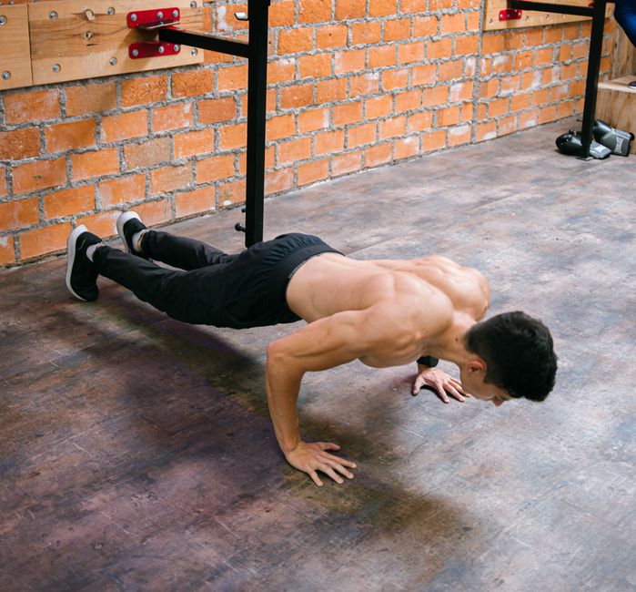 A fit man performs push-ups in a Ciudad de México gym, showcasing strength and dedication.