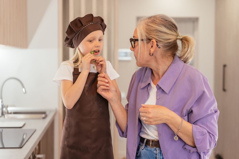 A grandmother and grandchild enjoying a cooking session in the kitchen, sharing quality time.