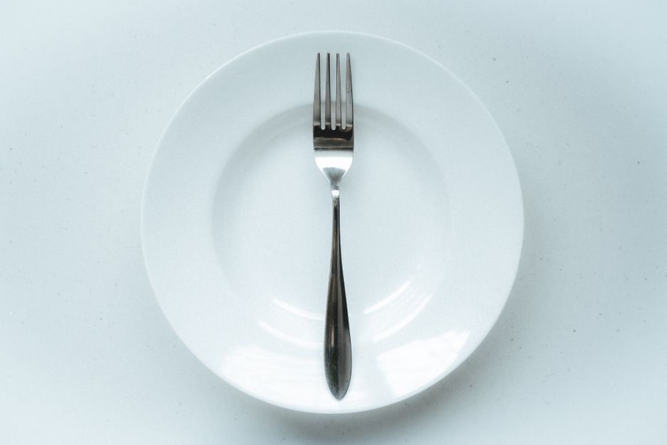 A minimalist setup with a fork centered on a white plate.
