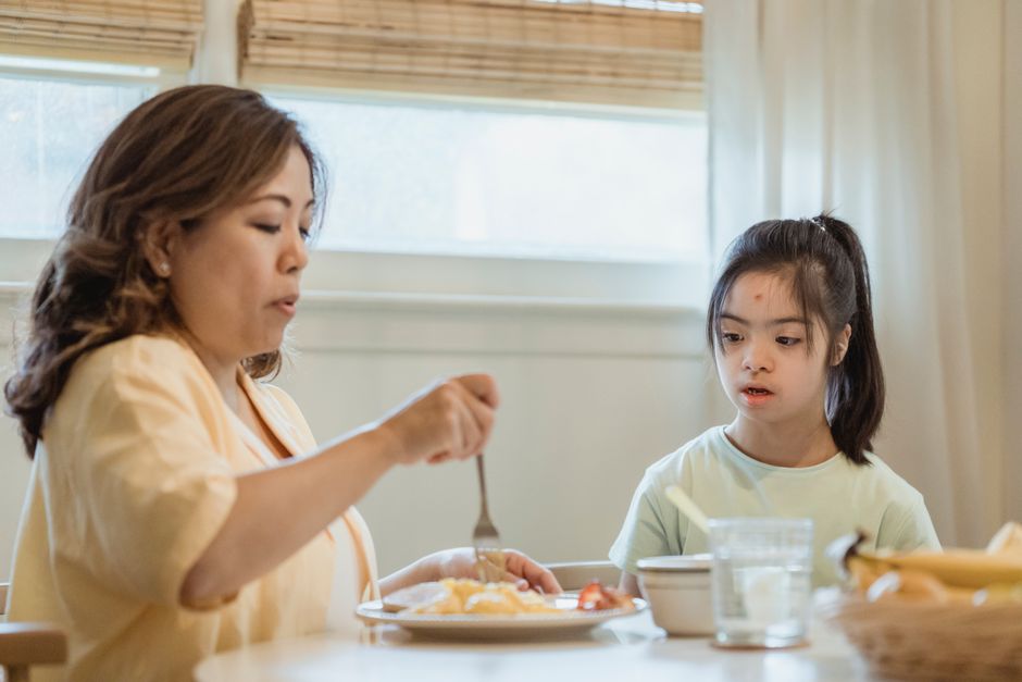 A mother and daughter share a peaceful breakfast at home, highlighting family bonding.