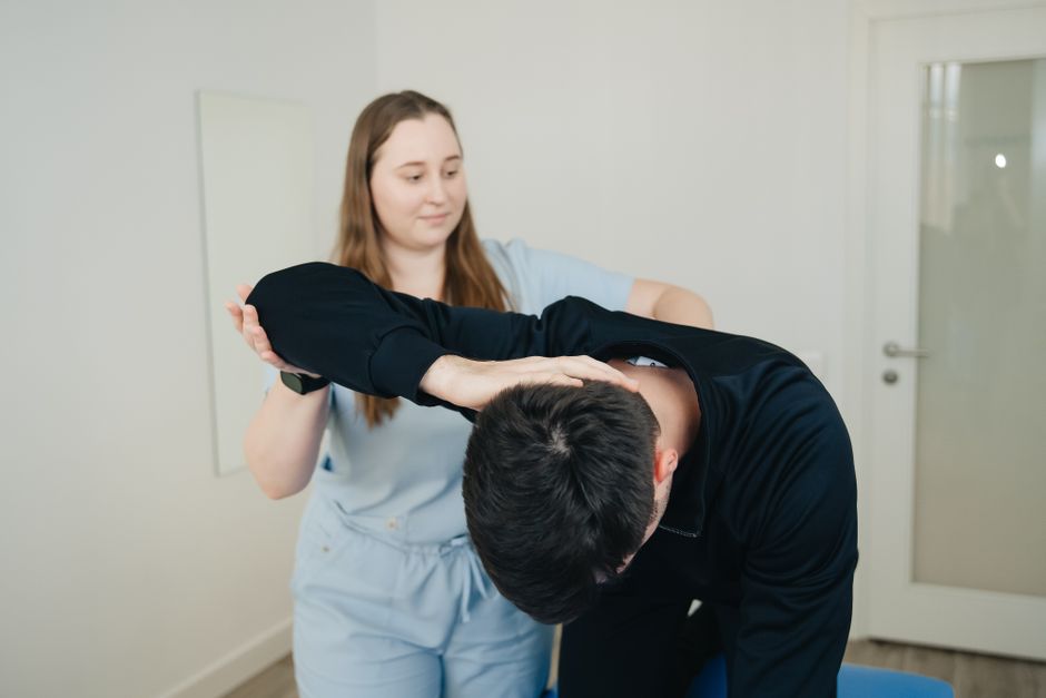 A physiotherapist aids a patient in a stretching exercise for rehabilitation.